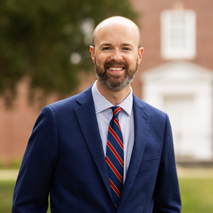 Portrait of Andrew T. Walker outdoors on a campus lawn
